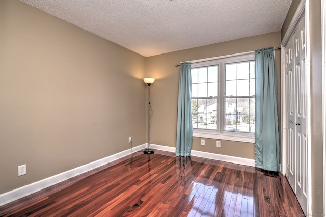 75 Redwood Dr Unit 510, East Haven, CT 06513 - unfurnished bedroom with baseboards, dark wood finished floors, and a textured ceiling