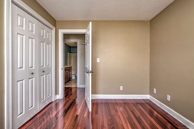 75 Redwood Dr Unit 510, East Haven, CT 06513 - unfurnished bedroom featuring a textured ceiling, a closet, dark wood finished floors, and baseboards