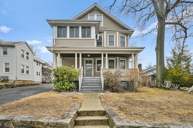 american foursquare style home featuring aphalt driveway and covered porch