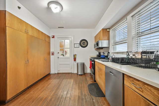 kitchen with visible vents, light countertops, hardwood / wood-style floors, brown cabinetry, and stainless steel appliances