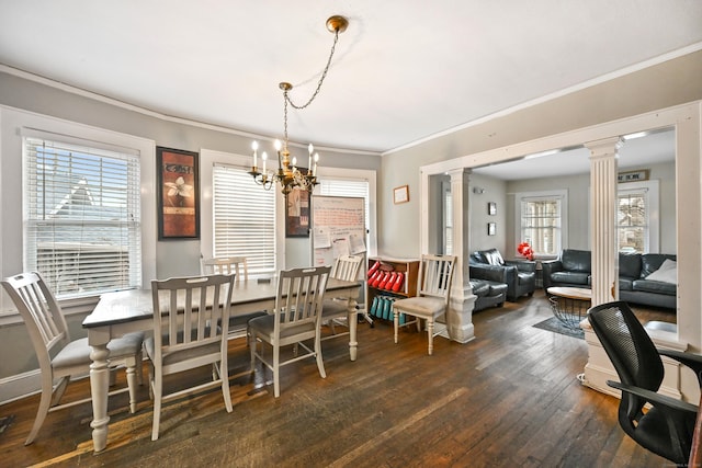 dining room featuring decorative columns, crown molding, and hardwood / wood-style flooring