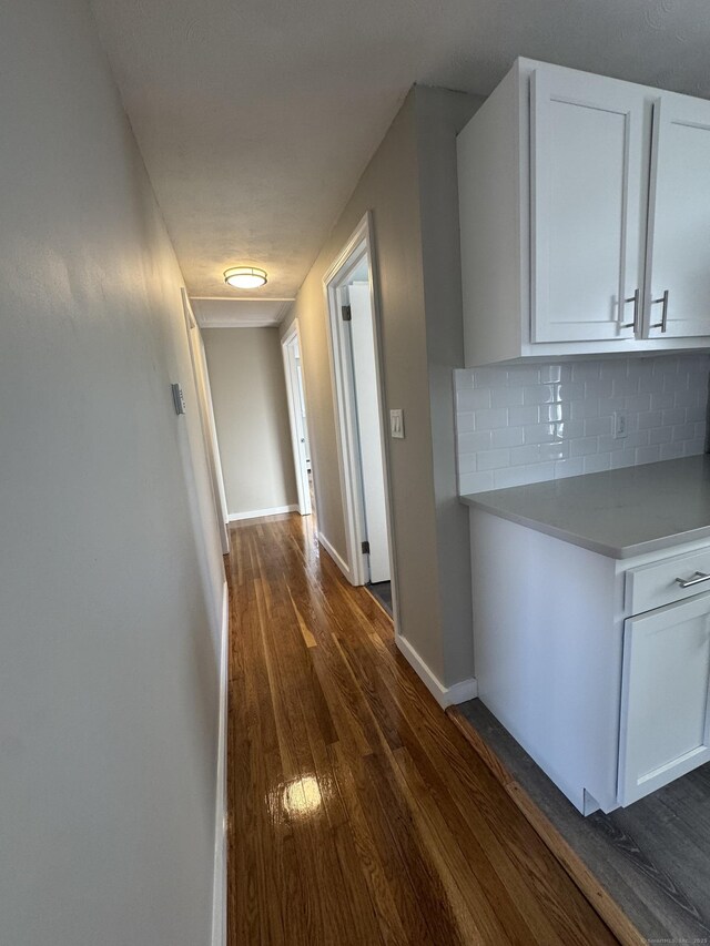 hallway with baseboards and dark wood-type flooring