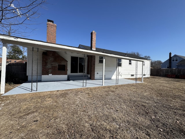 rear view of property with a patio, fence, a chimney, crawl space, and brick siding