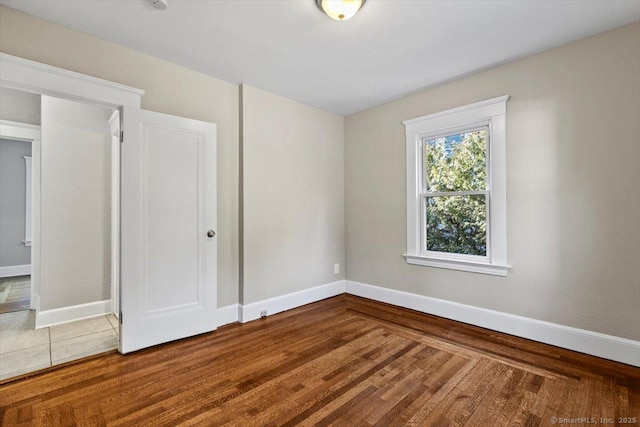 unfurnished room with baseboards and wood finished floors