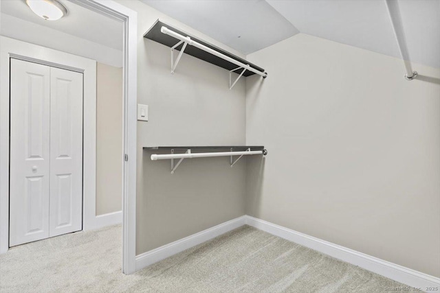 spacious closet featuring carpet and vaulted ceiling