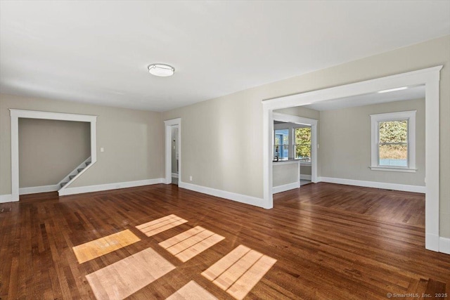 spare room featuring plenty of natural light, baseboards, and wood finished floors