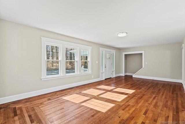 spare room featuring baseboards and wood finished floors