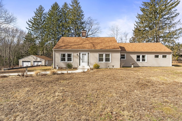 view of front of property with roof with shingles, a chimney, an outdoor structure, a front lawn, and a detached garage