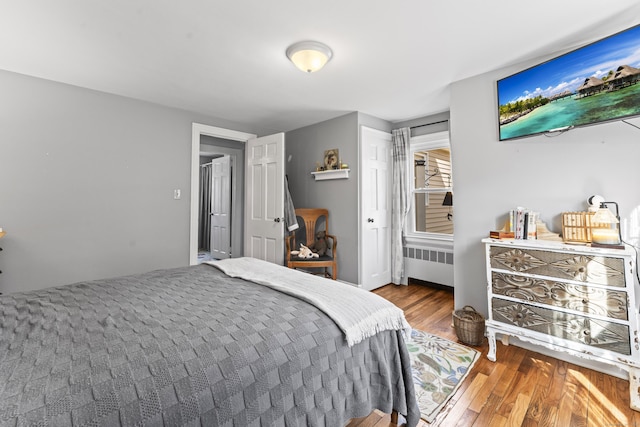 bedroom with radiator and wood finished floors