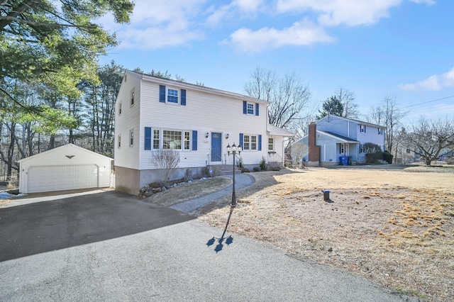 colonial house with a garage and an outdoor structure