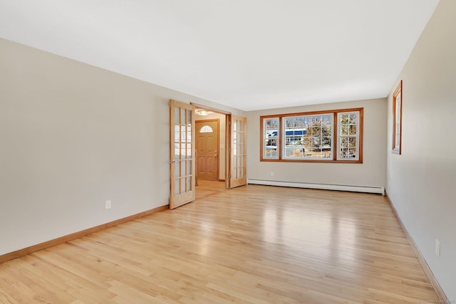 unfurnished room featuring baseboards, baseboard heating, and light wood-style floors