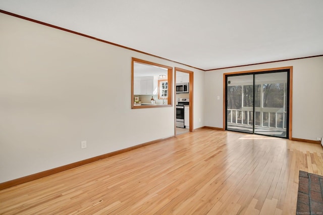 interior space with baseboards, ornamental molding, and light wood-style floors