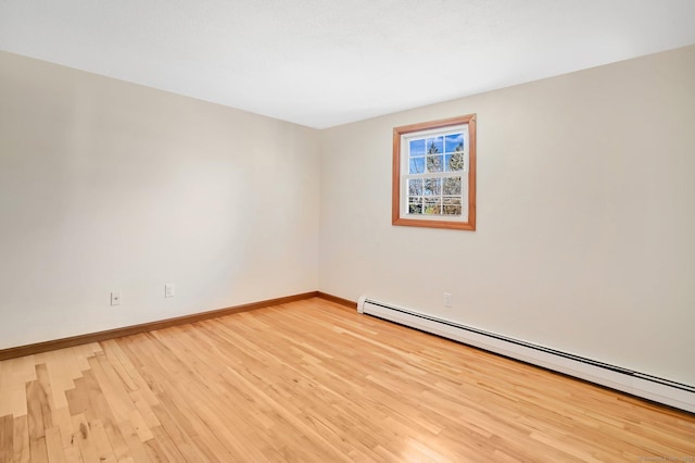 empty room featuring a baseboard radiator, light wood-style flooring, and baseboards