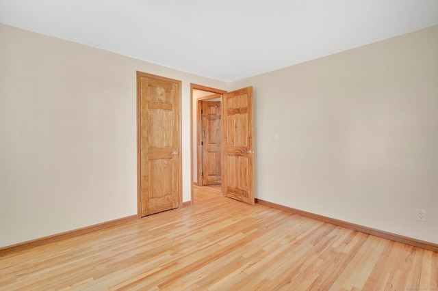 unfurnished room featuring light wood finished floors and baseboards