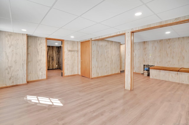 finished below grade area with a paneled ceiling, baseboards, wood finished floors, and recessed lighting