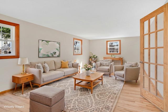 living area featuring light wood-style floors and baseboards