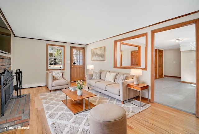 living area featuring a brick fireplace, crown molding, baseboards, and wood finished floors