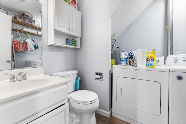 bathroom featuring toilet, separate washer and dryer, wood finished floors, vanity, and baseboards