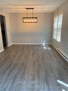 unfurnished dining area featuring wood finished floors and baseboards