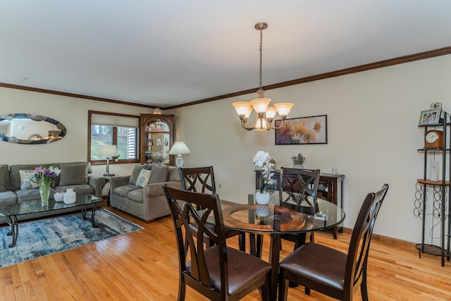 dining room featuring baseboards, a notable chandelier, ornamental molding, and light wood finished floors