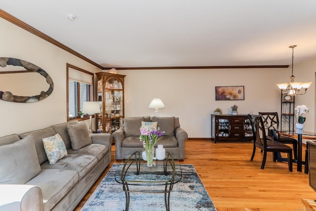 living room featuring baseboards, an inviting chandelier, light wood-style flooring, and ornamental molding