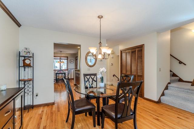 dining space with baseboards, an inviting chandelier, stairs, and light wood finished floors