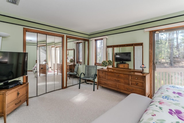 carpeted bedroom featuring visible vents and multiple windows