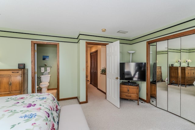 bedroom featuring light colored carpet, a closet, and baseboards