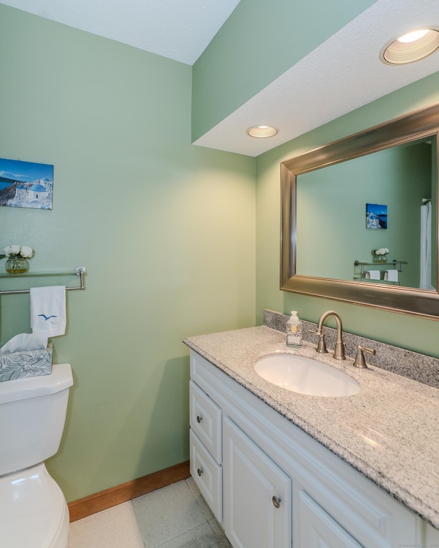 bathroom featuring tile patterned flooring, toilet, vanity, and baseboards