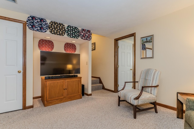 sitting room featuring light carpet, visible vents, stairs, and baseboards