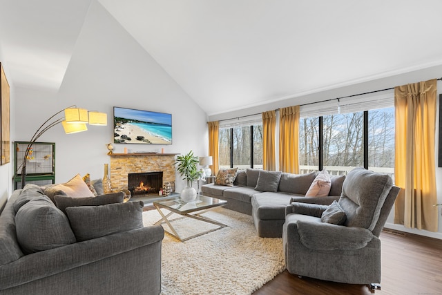 living room featuring a fireplace, high vaulted ceiling, dark wood-type flooring, and a wealth of natural light