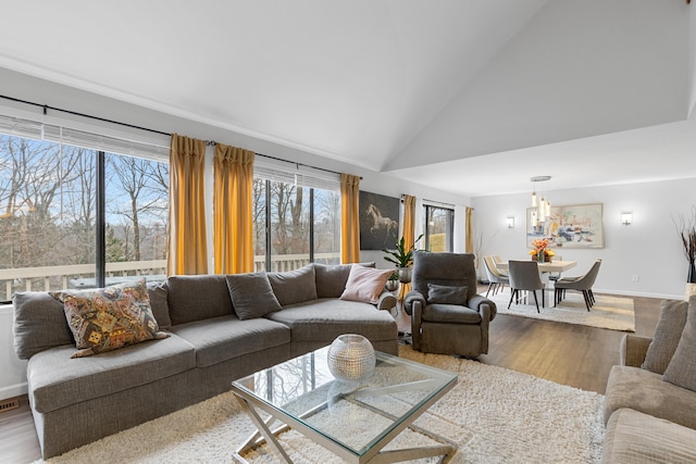 living room with high vaulted ceiling, visible vents, baseboards, and wood finished floors