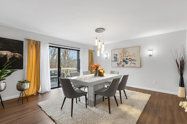 dining area with dark wood-style floors, baseboards, and a notable chandelier