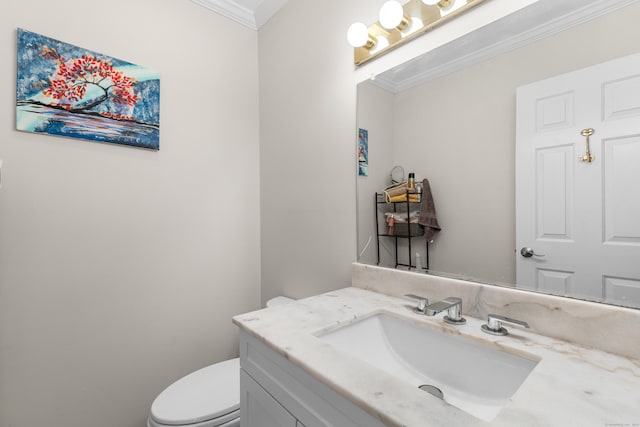 half bathroom with ornamental molding, vanity, and toilet