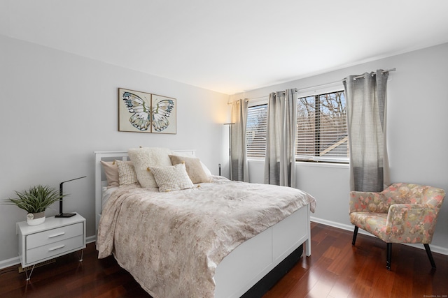 bedroom with dark wood-type flooring and baseboards