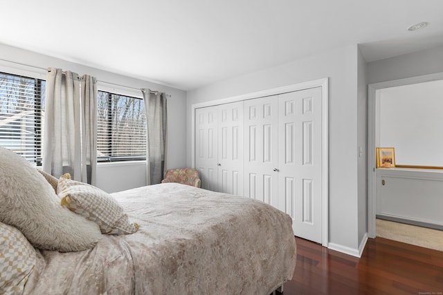 bedroom featuring a closet, wood finished floors, and baseboards