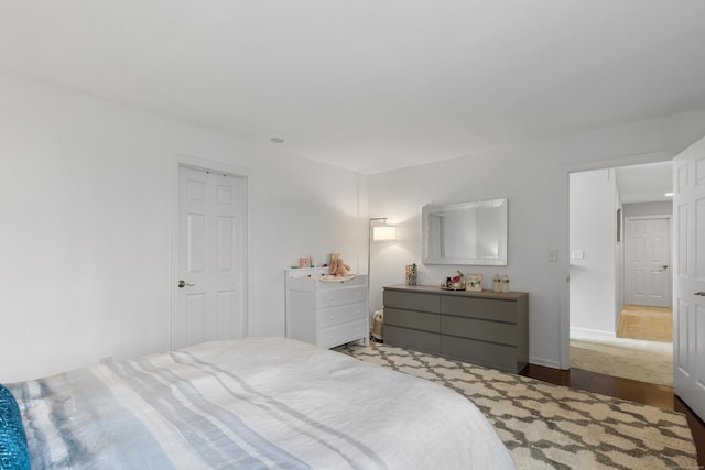 bedroom with wood finished floors and baseboards