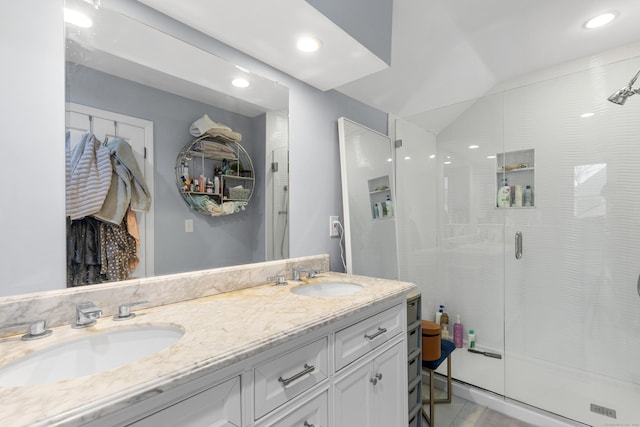 full bath featuring a stall shower, a sink, recessed lighting, and double vanity