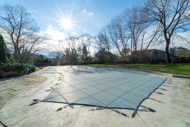 view of swimming pool featuring a patio area and a covered pool