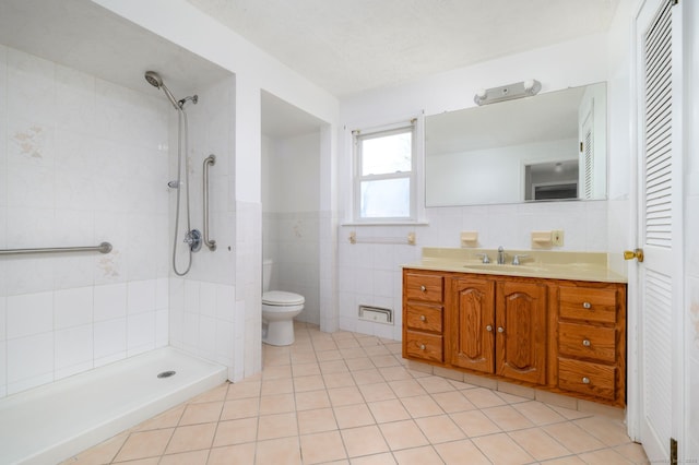 full bathroom featuring toilet, vanity, tile walls, and tiled shower