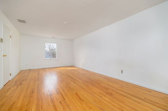 unfurnished room featuring light wood-style floors, baseboards, and visible vents