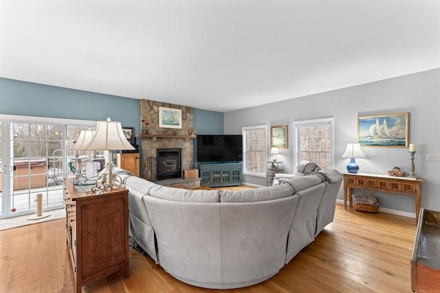 living room featuring plenty of natural light, light wood finished floors, baseboards, and a fireplace