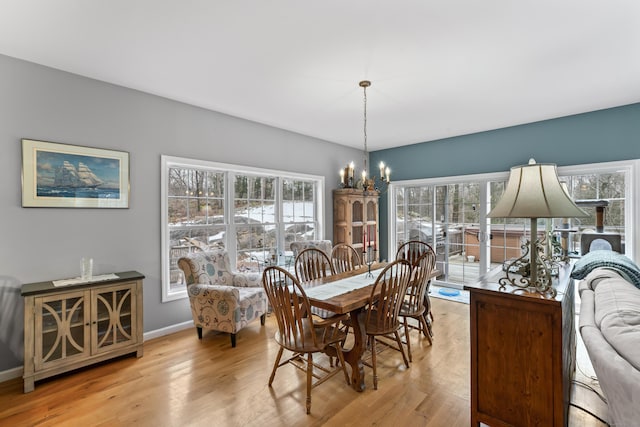 dining area featuring an inviting chandelier, baseboards, wood finished floors, and a wealth of natural light