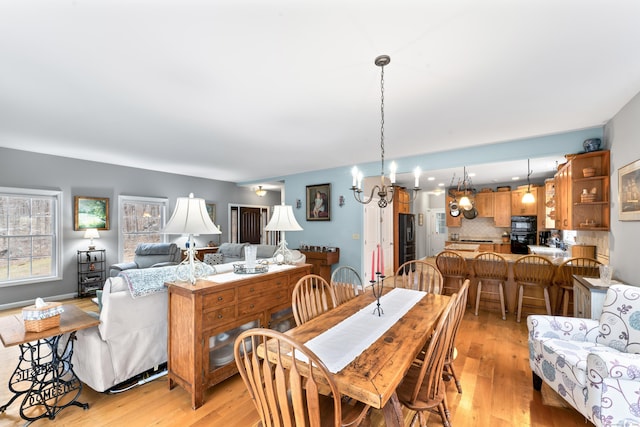 dining area featuring light wood finished floors and a chandelier