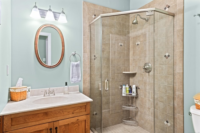 full bathroom featuring vanity, toilet, and a stall shower