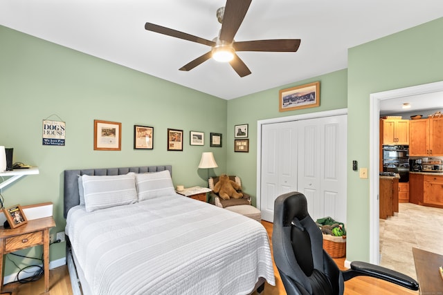 bedroom featuring light wood-style floors, baseboards, ceiling fan, and a closet