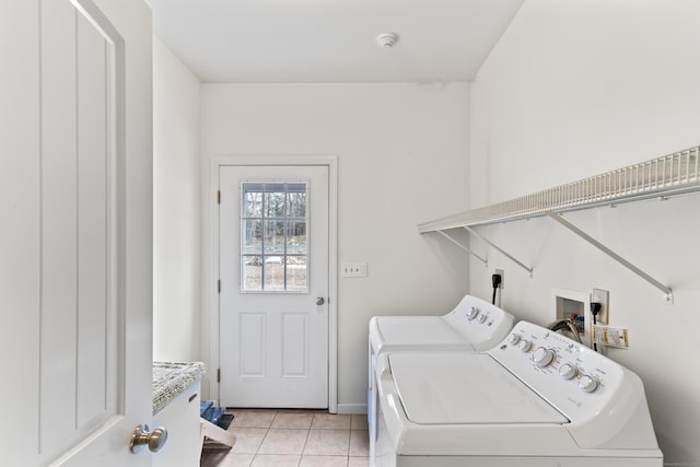 clothes washing area with light tile patterned floors, laundry area, and washer and clothes dryer