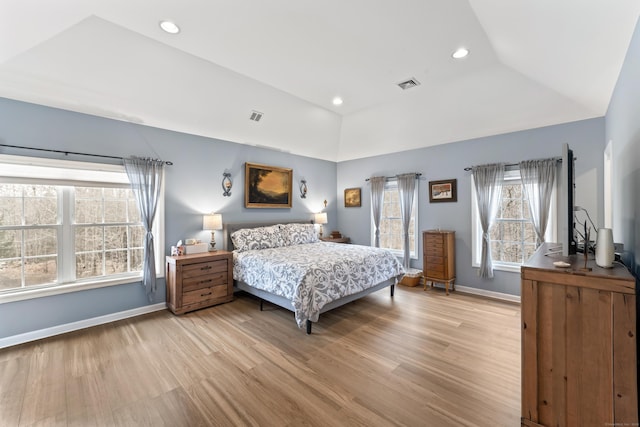bedroom with baseboards, multiple windows, light wood-style flooring, and visible vents