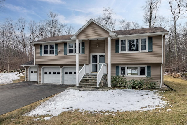 raised ranch featuring driveway and an attached garage