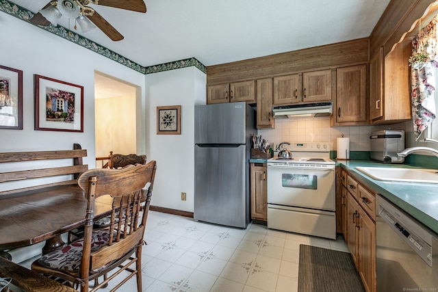 kitchen featuring decorative backsplash, appliances with stainless steel finishes, a ceiling fan, a sink, and under cabinet range hood